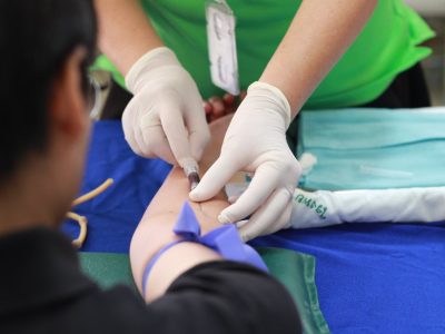 A healthcare professional administering an injection to a patient's arm during a medical procedure.
